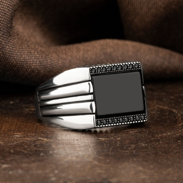 Black Onyx Stone Covered Small Zircon Stones Square Silver Ring with brown silk background and on brown ground 