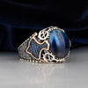 Blue Tiger Eye Stone Silver Men's Ring with Small Blue Zircons Circled Gold Line on Sides is blue silk background and on white floor 