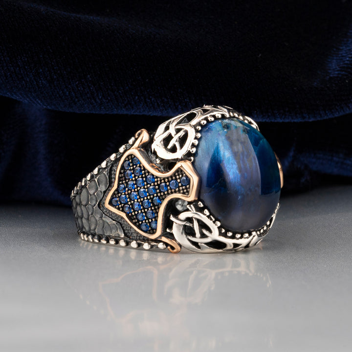 Blue Tiger Eye Stone Silver Men's Ring with Small Blue Zircons Circled Gold Line on Sides is blue silk background and on white floor 